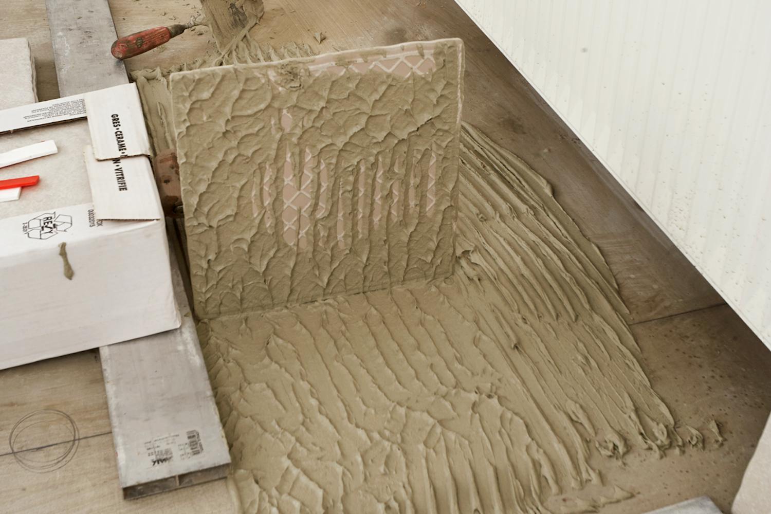 Her er flisen dekket av et tynt lag flislim, etter at den har ligget på gulvet. Slik skal skal det se ut.